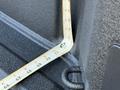 A measuring tape is bent at a right angle inside the bed of a 2024 Chevrolet Silverado 1500