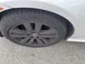 A close-up of a black rim on a 2011 BMW 3-Series showing a tire with low tread depth and visible dirt on the wheel