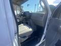 Interior of a 2009 Ford Econoline with gray upholstery featuring two front seats and a dashboard with controls and storage compartments