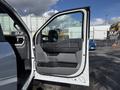 A 2024 Ford F-550 driver's side door is open displaying the interior door panel with control buttons and handle