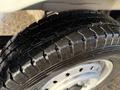 Close-up of a tire from a 2008 Suzuki Carry showing deep tread patterns and a shiny surface