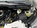 Engine compartment of a 2022 Ford Transit with various components visible including hoses a coolant reservoir and a battery