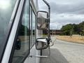 A 2018 Ford Econoline with a silver side mirror view highlighting its reflective surface and extended arm