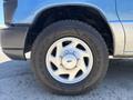 Close-up of a silver wheel and tire from a 2008 Ford E-350 showcasing five spokes and a textured tire labeled Wrangler Goodyear