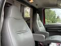 Two gray vinyl seats inside a 2007 Ford F-550 with armrests and a simple design