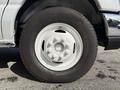 A white wheel with multiple lug nuts and a tire on a 2019 Ford Econoline