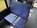 A blue upholstered seat with safety straps inside a vehicle