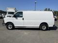 A white 2016 GMC Savana van is parked showing its side profile with a high roof and large cargo area