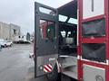A red 2006 E-One Typhoon fire truck with an open door revealing the interior seating area and equipment storage
