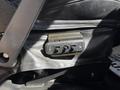 A control panel with three switch buttons mounted on the side of a black leather seat in a 2017 Chevrolet Express