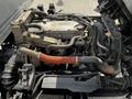 Engine compartment of a 2016 Isuzu NQR showing various pipes and components including an orange hose and multiple metal parts
