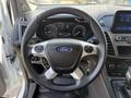 The interior view of a 2021 Ford Transit Connect showing the steering wheel with the Ford logo and dashboard with speedometer and controls