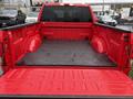A red 2015 Ford F-150 pickup truck bed with a black rubber liner and no cargo inside