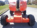 A 2008 JLG Boom Lift with large rubber tires and a bright orange body positioned on a flat surface