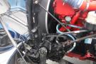 Close-up of a 2015 Kenworth T660 engine showing detailed components including hoses and mechanical parts in red and black colors