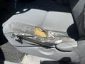 The driver's side seat of a 2010 Toyota Tacoma showing significant wear with torn fabric and exposed foam on the side rail