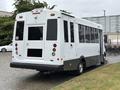 A white 2020 Chevrolet Express bus with a black lower section and accessible features at the rear