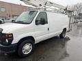 A white 2008 Ford Econoline van with a utility lift attached to the roof and a black front grille