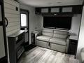 Interior of a 2022 Aspen Trail featuring a gray leather sofa and modern cabinetry with a sleek design and wood flooring