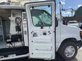 A 2008 Ford Econoline van with an open side door exposing the interior features such as equipment storage and control panels