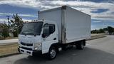 A white 2018 Mitsubishi Fuso FE box truck with a silver cargo area and multiple orange lights on the front roof