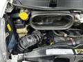 Engine compartment of a 2021 RAM Promaster featuring various components including a black air intake hose and a yellow coolant reservoir cap