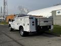 A white 2016 Ford F-350 SD service truck with a utility bed and a Tommy Gate liftgate on the rear