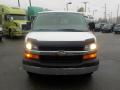 Front view of a white 2011 Chevrolet Express with a black hood and chrome grille featuring the Chevrolet emblem