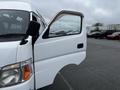 A white 2002 Nissan Van with an open driver's side door showing the interior and a partially visible side mirror