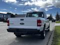 A white 2010 Ford Ranger pickup truck showing the rear with a visible Ford logo and the word Ranger on the tailgate
