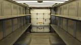 Interior view of a 2011 Ford Econoline cargo van featuring metal shelving on both sides and a closed rear door