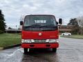 A red 2001 Toyota Dyna with a prominent star logo on the front, featuring a simple design and large windshield, positioned in a slightly angled view