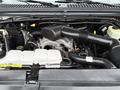 A 2001 Ford F-350 engine with various components visible including hoses, a black air intake, and a clear coolant reservoir