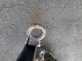 Top view of a circular metal hitch attachment on a trailer with visible wear and rust showing signs of use