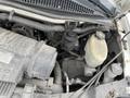 A close-up view of the engine compartment of a 2014 GMC Savana showing various components including the air intake and fluid reservoir