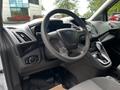 A 2014 Ford Transit Connect interior featuring a steering wheel gear shift and dashboard controls