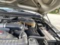 A 2007 Ford F-350 SD engine compartment featuring the air filter intake and various engine components including hoses and a battery