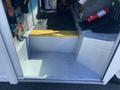 Interior view of a 2012 Ford Econoline showing the metal floor and steps of the entryway with a fire extinguisher visible on the side