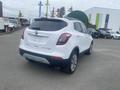 A white 2018 Buick Encore is parked with its rear view visible showing its distinctive tail lights and a clean design