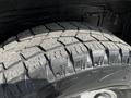 A close-up view of a worn tire tread on a 2003 Mitsubishi Delica showing deep grooves and a rugged design suitable for off-road driving