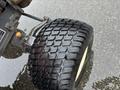 Close-up of a black tire with a deep tread pattern mounted on a metal wheel from a 2012 Kubota F3680 agricultural vehicle