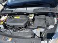 An overhead view of the engine compartment of a 2014 Ford Escape showing the engine block components and various electrical connections
