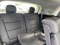 The interior of a 2015 Kia Sorento showing two black leather rear seats with a floor mat partially removed