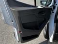 Close-up of the open driver-side door of a 2022 Ford Transit showcasing the interior handle and armrest design