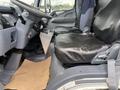 Interior view of a 2008 Mitsubishi Fuso FE180 showcasing the driver's seat and passenger seat both covered in black fabric with a gray dashboard and floor mat