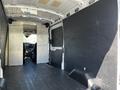 Interior view of a 2022 Ford Transit van featuring empty cargo space with paneling and a driver's area visible in the background