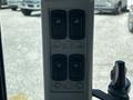 Control panel of a 2018 New Holland Boomer 45 featuring four buttons with symbols for lights, tractor, and other functions
