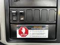 Dashboard control panel of a 2019 International 4300 featuring switches and a checklist for safely exiting the tractor