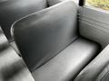 Interior view of a 2015 Spartan School Bus showing gray vinyl seating with a smooth surface and slightly textured finish