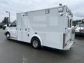A 2016 Chevrolet Express vehicle with a white exterior designed for medical or emergency services featuring side doors and a rear step.